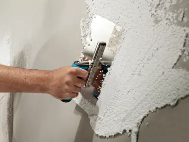 Hand mit Kelle verputzt eine Wand