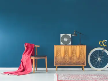 Eine blaugestrichene Wand mit Stuhl und Sofa im Vordergrund