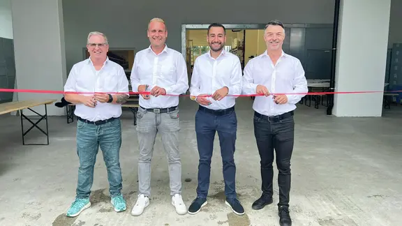 Andreas Ulrich, Marco Kern, Ralph Hermann und Walter Eigenmann stehen von links nach rechts aufgereiht jeweils mit einer Schere vor einem roten Band zur Eröffnung des Lagerstandorts Wilen