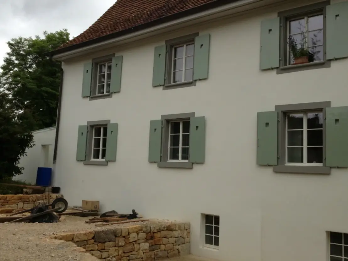 Ansicht der Fassade mit grünen Fensterläden und sechst Fenstern