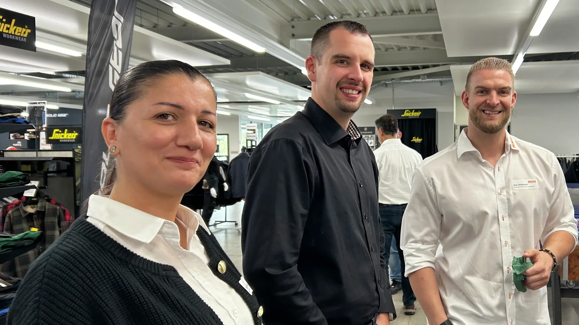 Rana Mehaidli steht neben zwei Teilnehmern des Fixit-Impuls-Flash, alle schauen in die Kamera