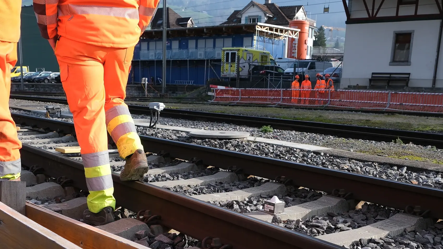 Gleisbereich am Bahnhof Schwyz mit Bauarbeitern und Fixit POR Silo im Hintergrund