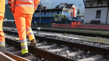 Gleisbereich am Bahnhof Schwyz mit Bauarbeitern und Fixit POR Silo im Hintergrund