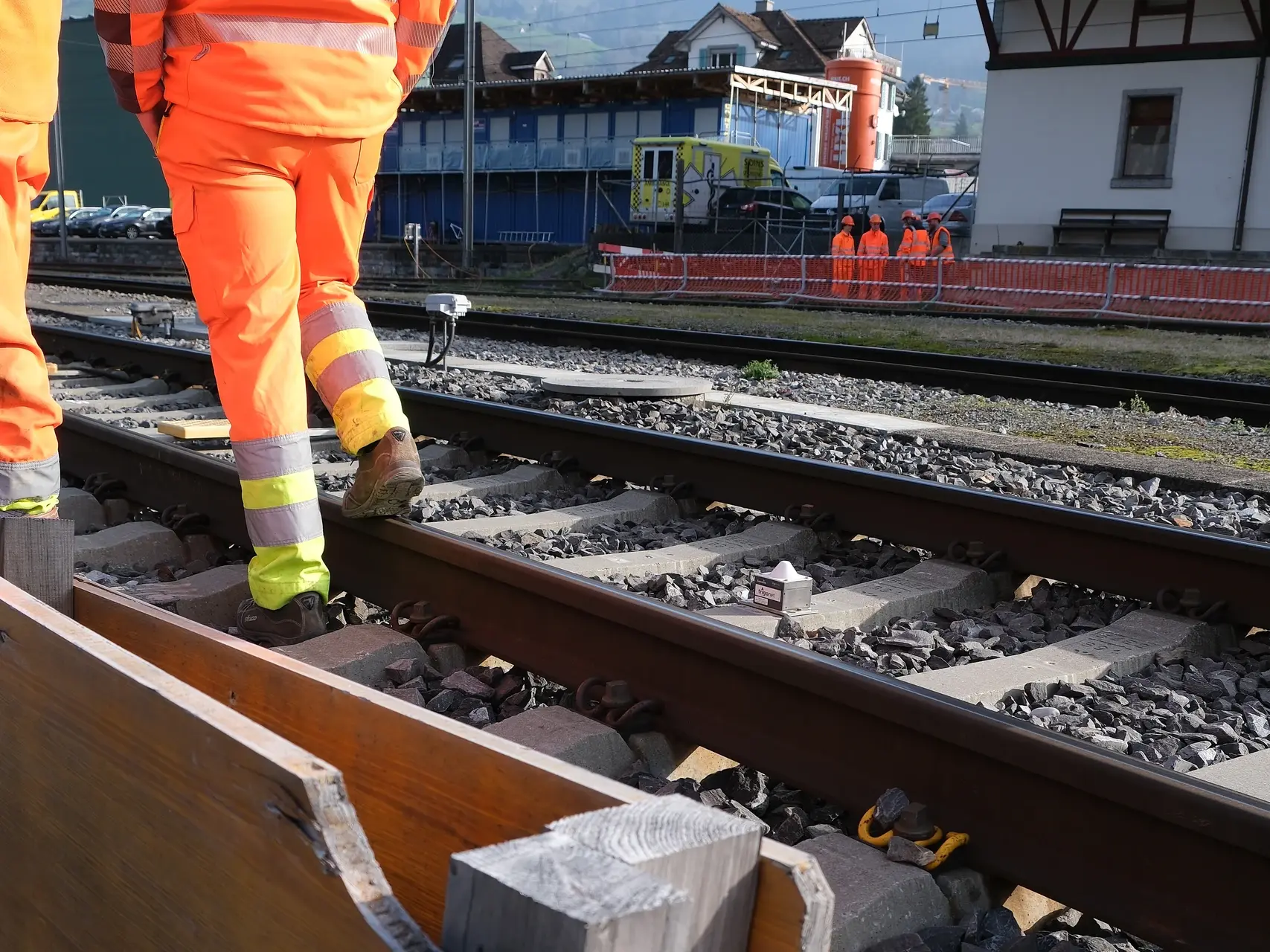 Zone de voies ferrées à la gare de Schwyz avec des ouvriers et le silo Fixit POR en arrière-plan