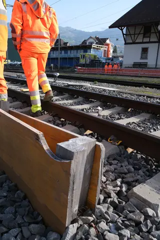 Gleisbereich am Bahnhof Schwyz mit Bauarbeitern und Fixit POR Silo im Hintergrund