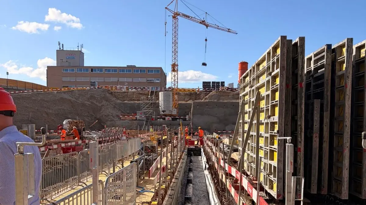 Vue d'une longue tranchée contenant le conduit d'aération et du béton cellulaire Fixit POR utilisé comme remblai ; à l'arrière-plan, le silo Fixit orange