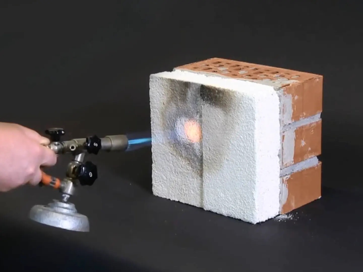 Le bec Bunsen à flamme bleue et chaude est dirigé directement sur l'enduit isolant Fixit 222 Aerogel.
