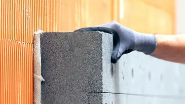 Des panneaux isolants en PSE sont collés sur un mur en briques