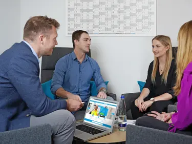 4 people sitting around a table, discussing