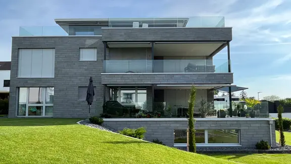 Maison individuelle avec des dalles de pierre grise sur l'ITE grâce à Greutol StoneEtics®.