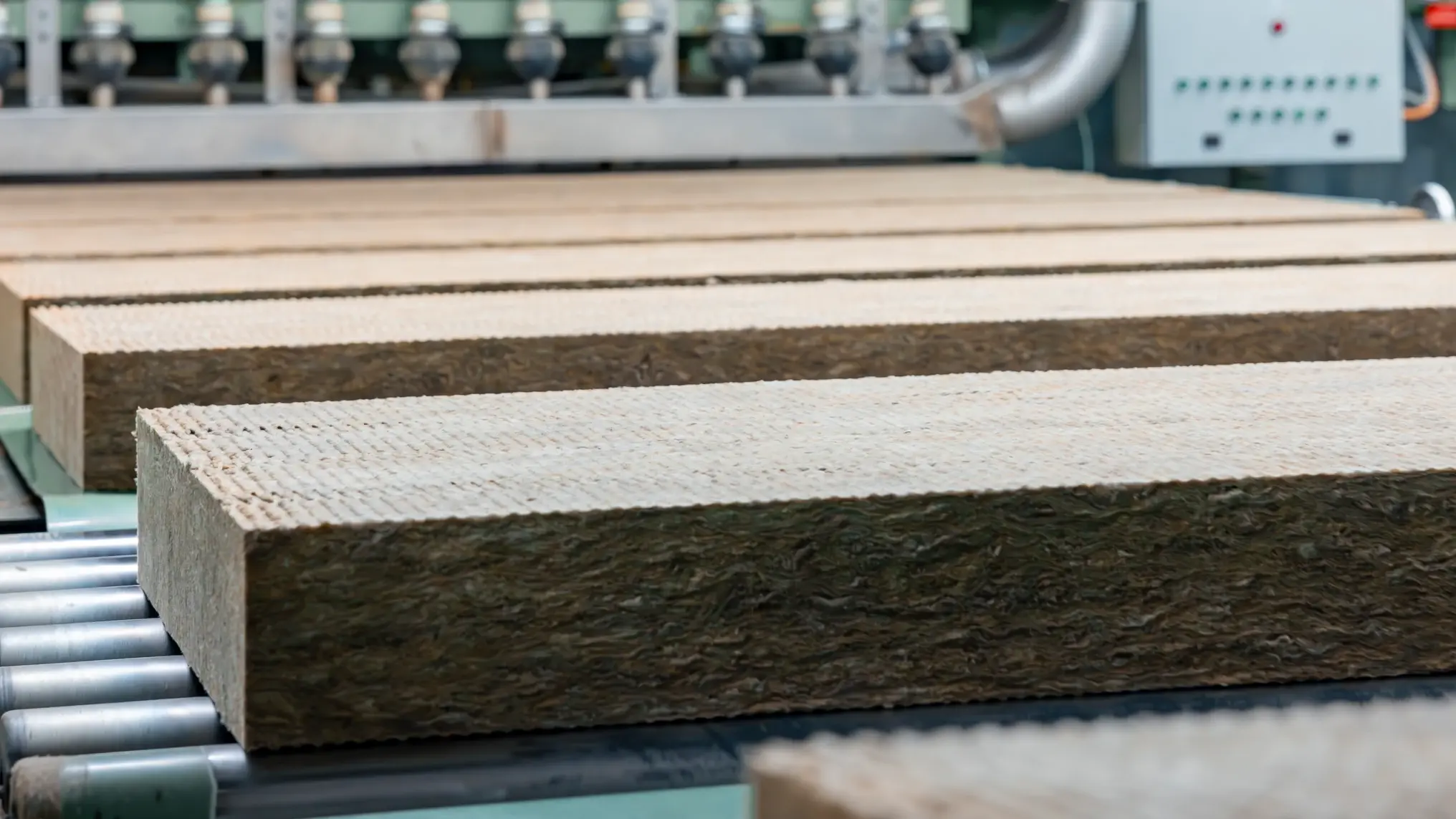 Zugeschnittene Steinwolle-Dämmplatten laufen über ein Rollband in der Flumroc Produktionshalle