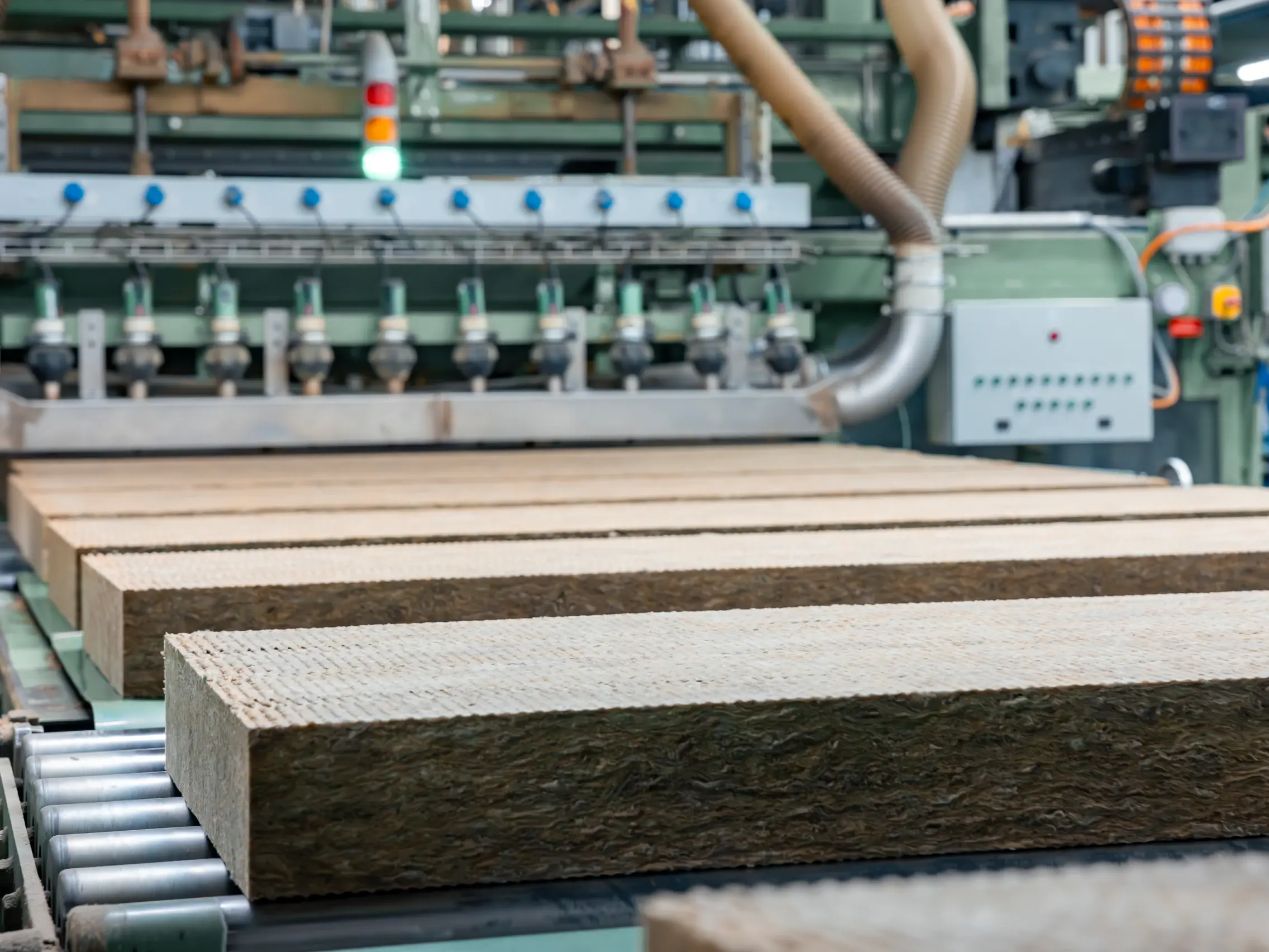 Zugeschnittene Steinwolle-Dämmplatten laufen über ein Rollband in der Flumroc Produktionshalle