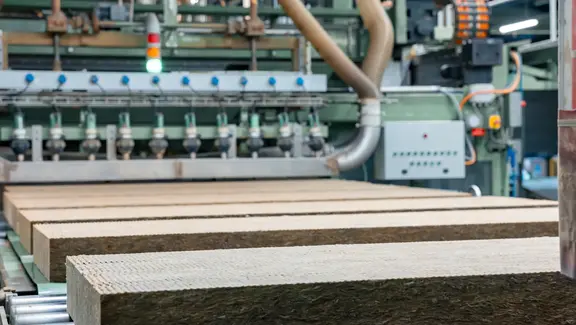 Zugeschnittene Steinwolle-Dämmplatten laufen über ein Rollband in der Flumroc Produktionshalle