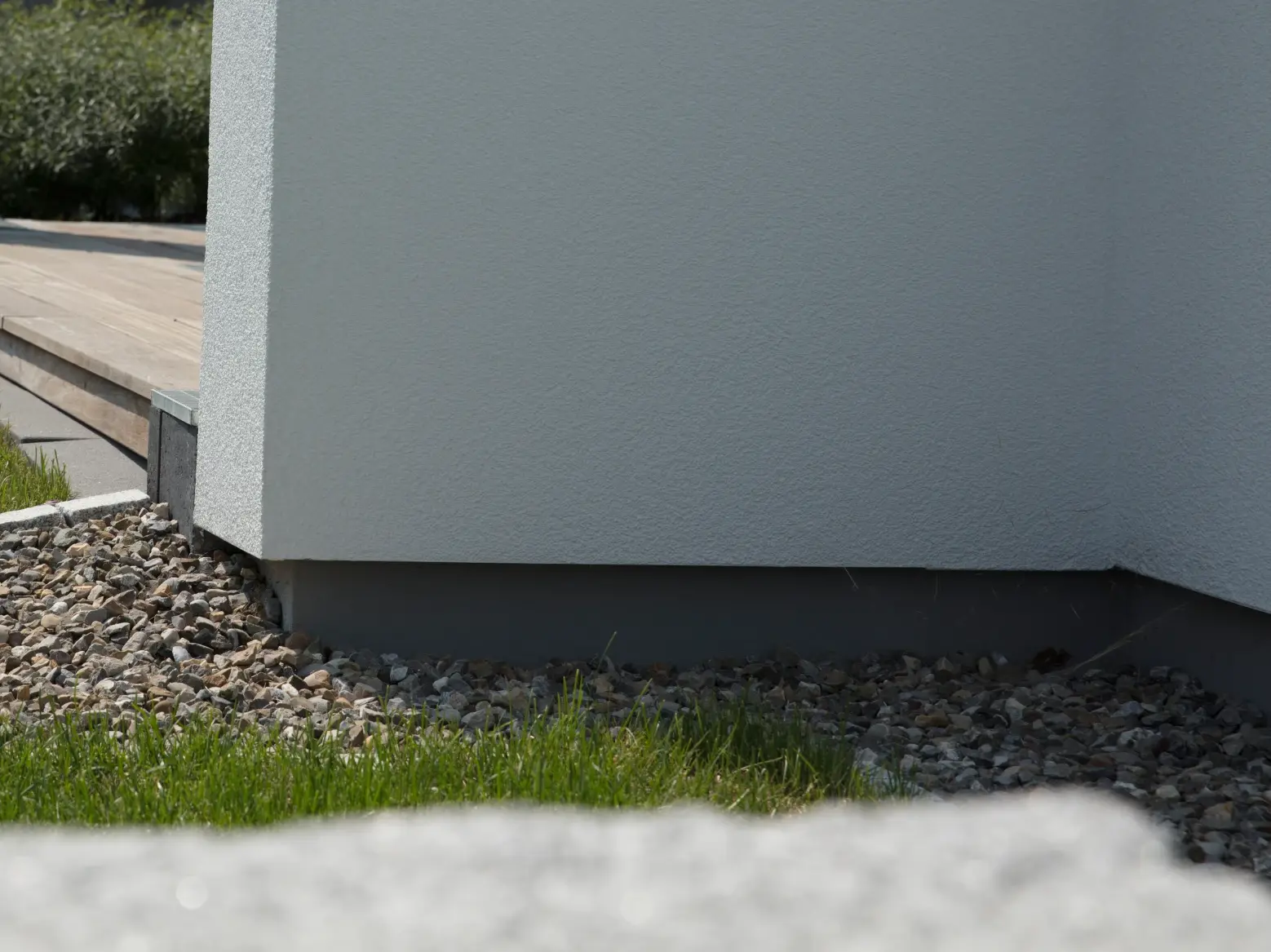 Sockel Detailansicht mit kleinem Rücksprung und Kiesbett zu einer Rasenkante