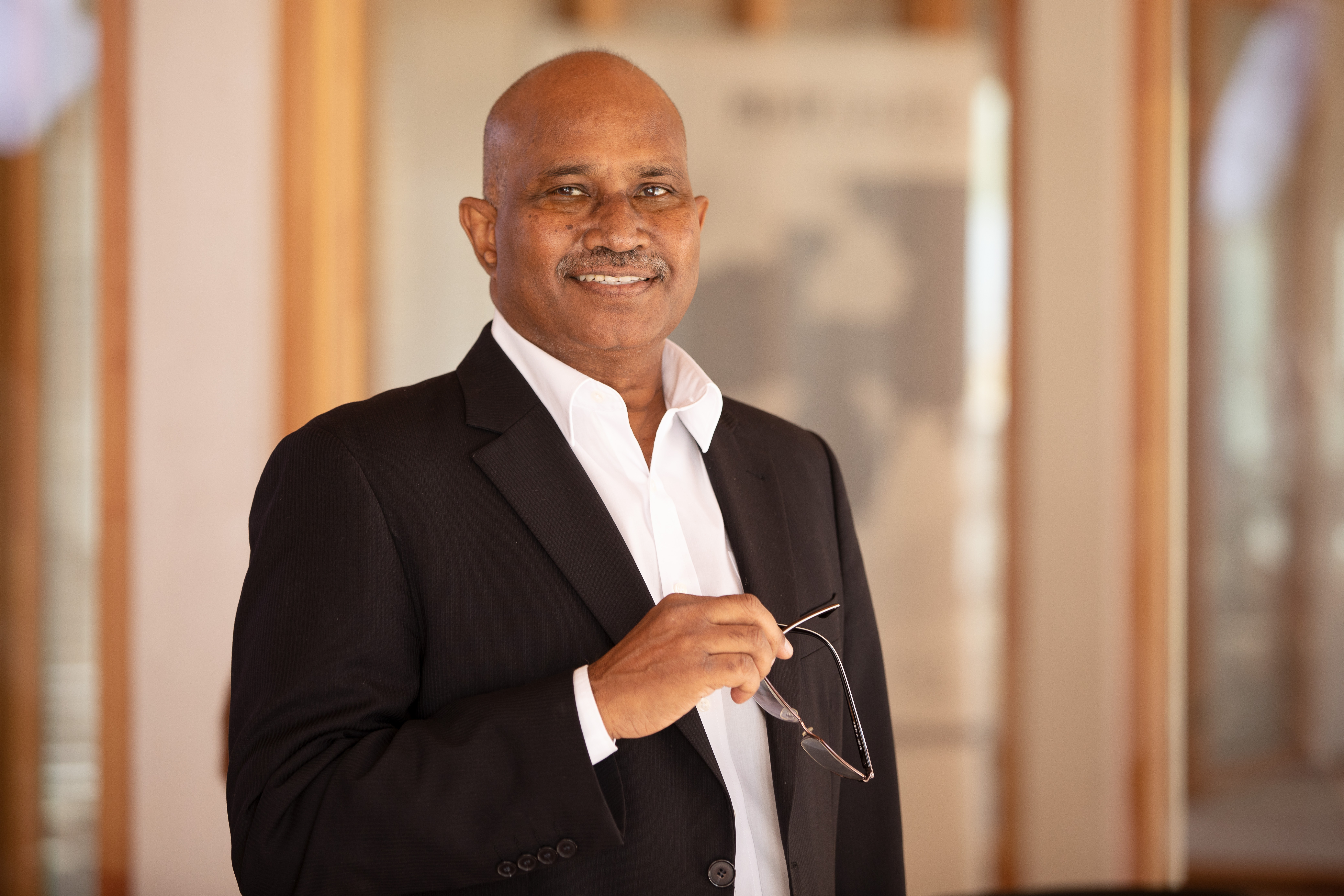 Ein Mitarbeiter steht im Vordergrund eines Büros