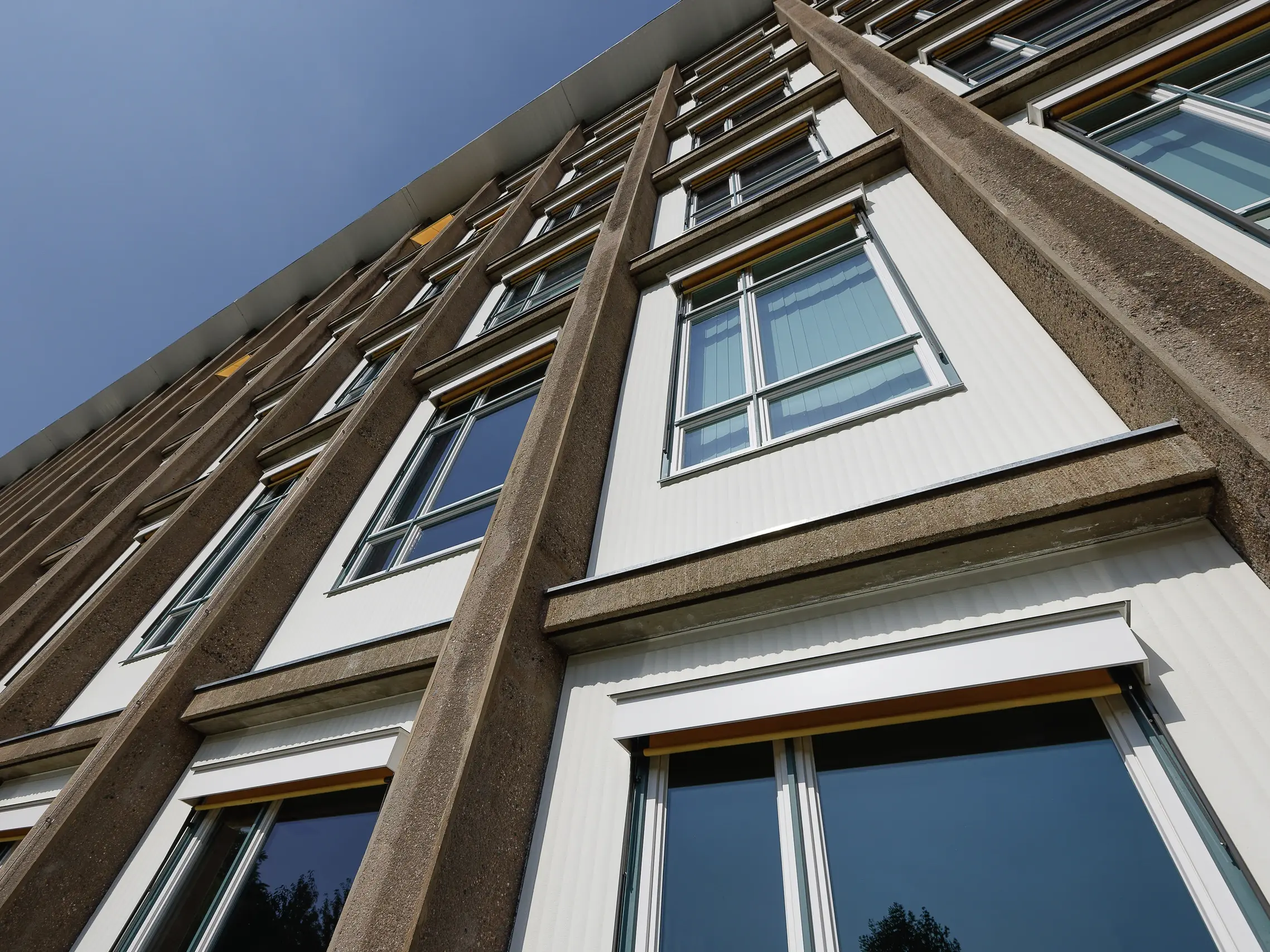 Umfangreiche Fassadengestaltung im Sanierungsprojekt: Kammzug-Struktur und historische Elemente.