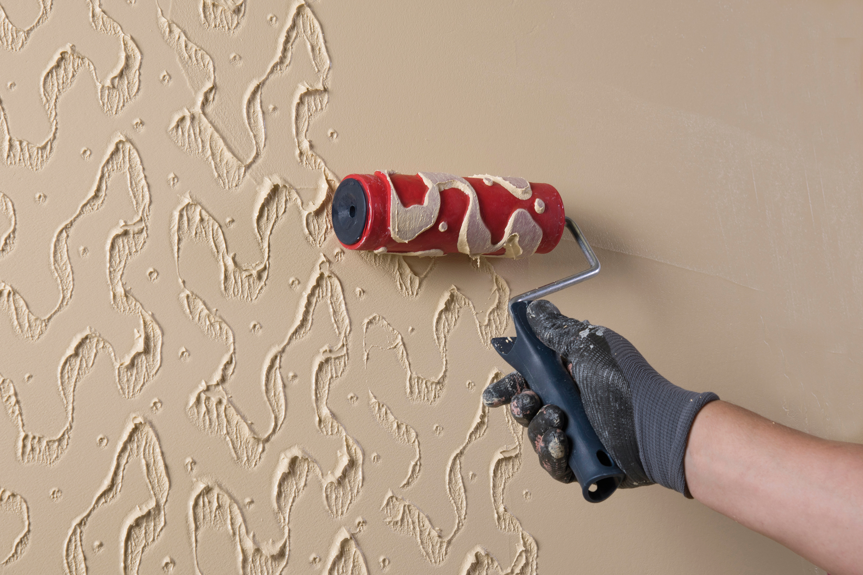 Eine gestaltete Putzoberfläche wird mit einem Roller aufgetragen