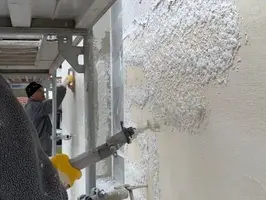 Handwerker beim Auftragen des Oberputzes auf die Außenfassade