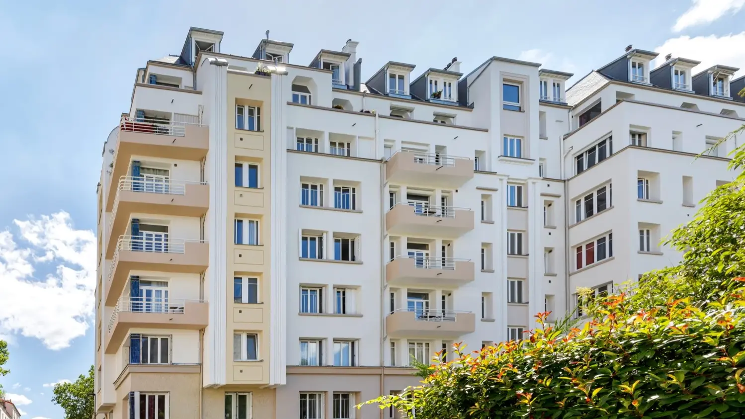 Seitenansicht des Mehrfamilienhauses  «Pierre de Coubertin» mit Balkonen und und der zweifarbigen Fassade
