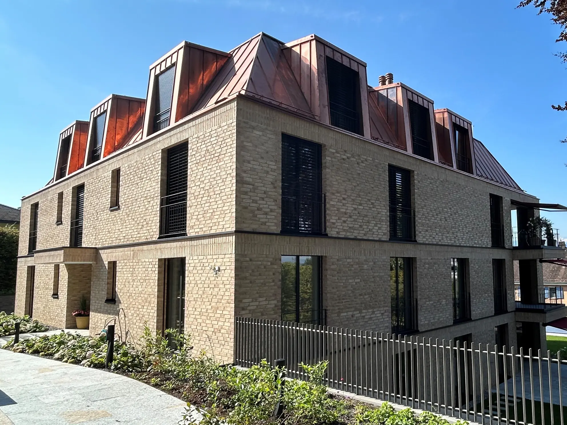 Stadtvilla im Bellerive-Quartier mit beigem Klinker-Sichtmauerwerk und einem stilvollen Kupferblechdach