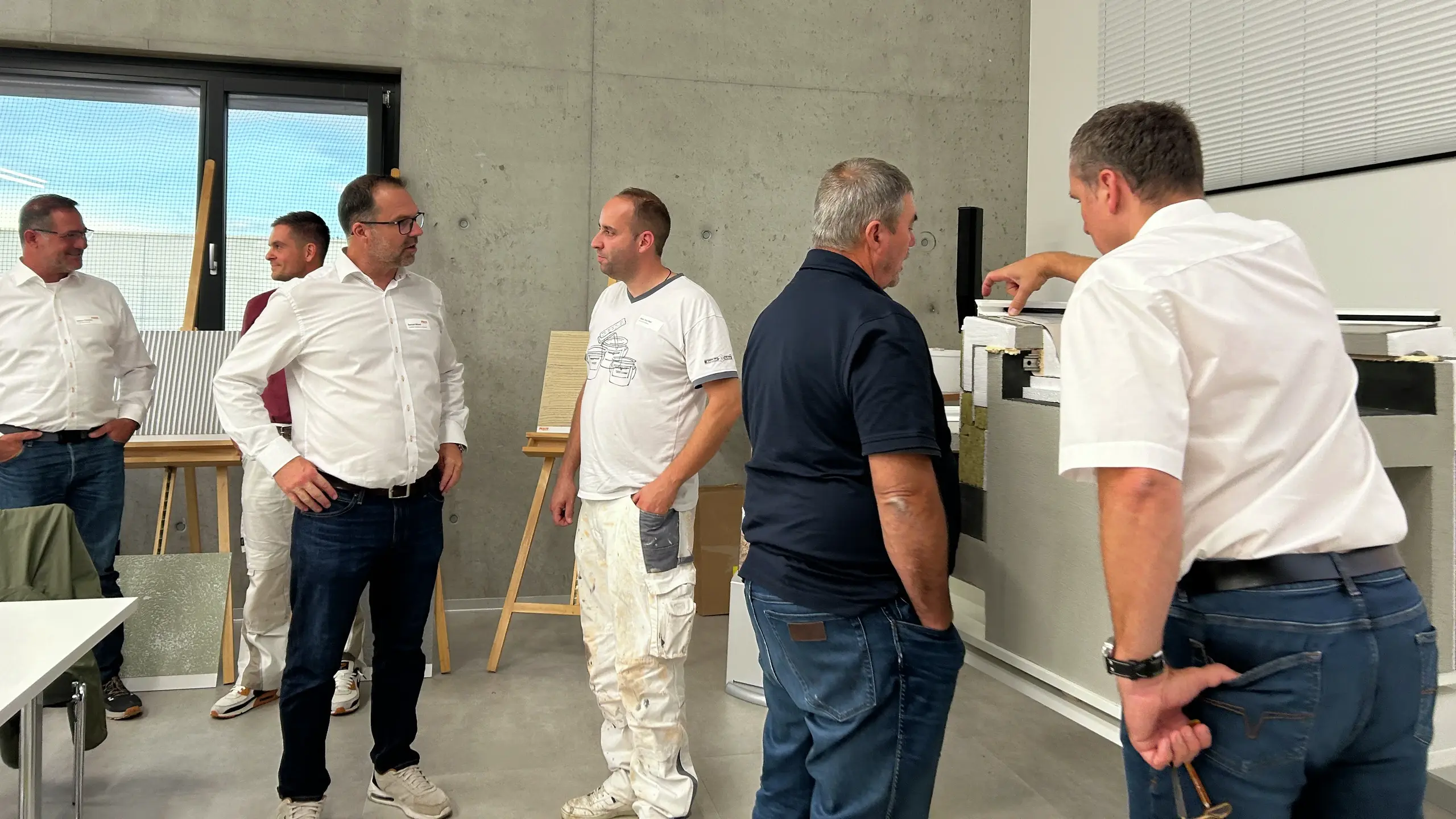 Plusieurs groupes de deux personnes discutent devant les panneaux d'échantillons Fixit.