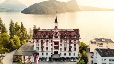 Un château historique au bord du lac avec une petite tour a été transformé en hôtel