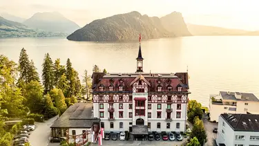 Un château historique au bord du lac avec une petite tour a été transformé en hôtel