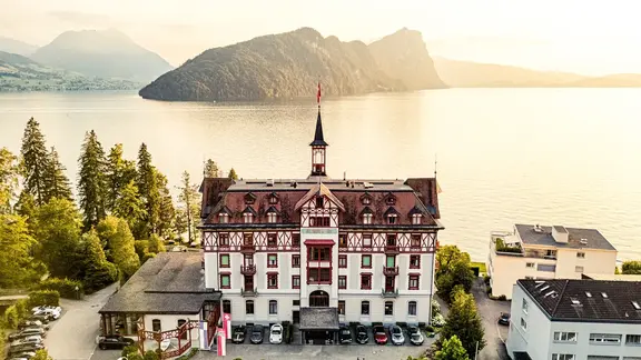 Un château historique au bord du lac avec une petite tour a été transformé en hôtel
