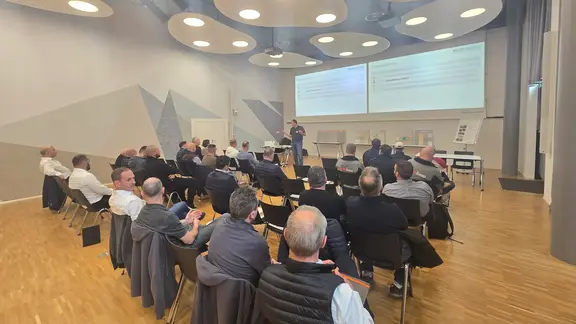 Weitwinkelaufnahme des Seminarraums bei der SMGV in Wallisellen mit den Gästen und den Präsentationen von Fixit