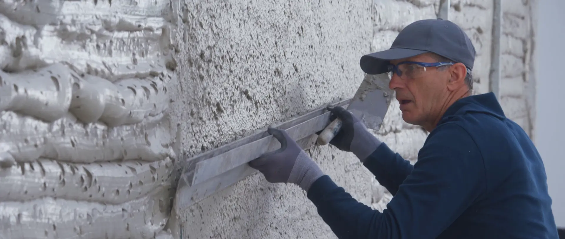 Glätten der Dämmputzschicht für eine gleichmäßige Oberfläche bei der professionellen Fassadendämmung