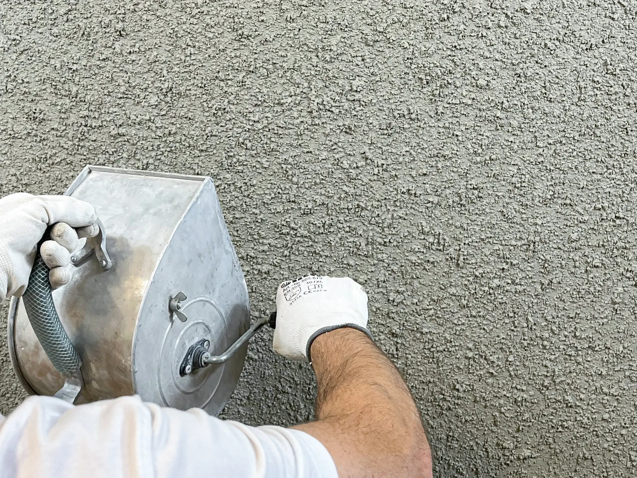 Verarbeitung von Wormser Putz mit dem Wormsergerät werden die Körner auf den noch feuchten Putz angeworfen