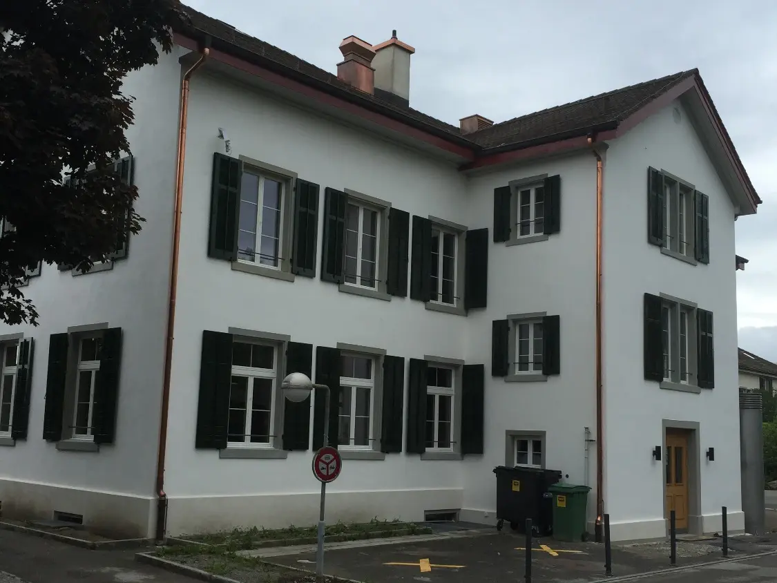 Retro dell'edificio con un avancorpo a forma di L e posti auto