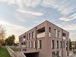 Modernes, energieeffizient gedämmtes Mehrfamilienhaus mit großen Fenstern und Balkonen.