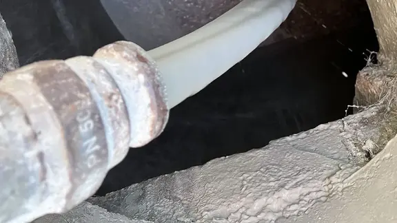 Fixit POR béton mousse s'écoule du tuyau de chape dans le puits préparé