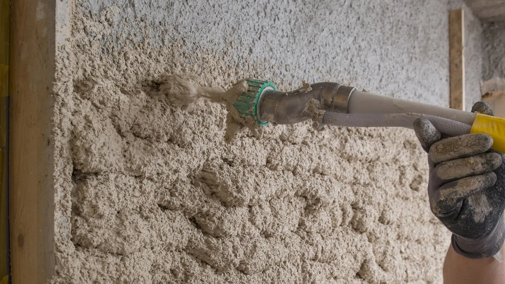 L'enduit isolant est pulvérisé sur le mur à l'aide d'une buse de pulvérisation.