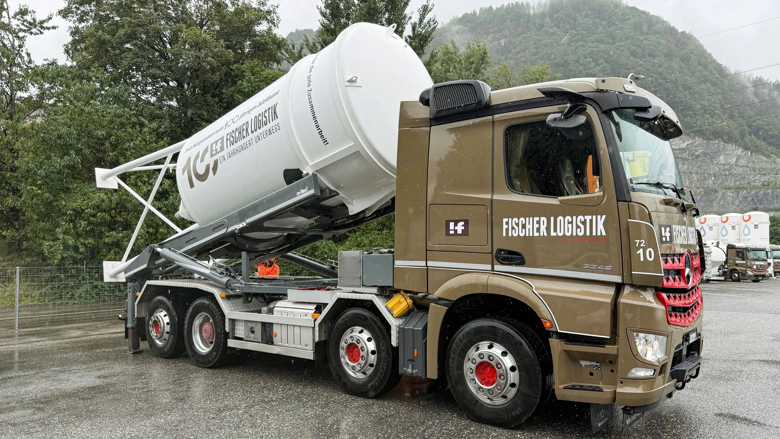 Seitenansicht LKW der Fischer Logistik mit dem weissen Jubiläumssilo der Fixit schräg aufgeladen.