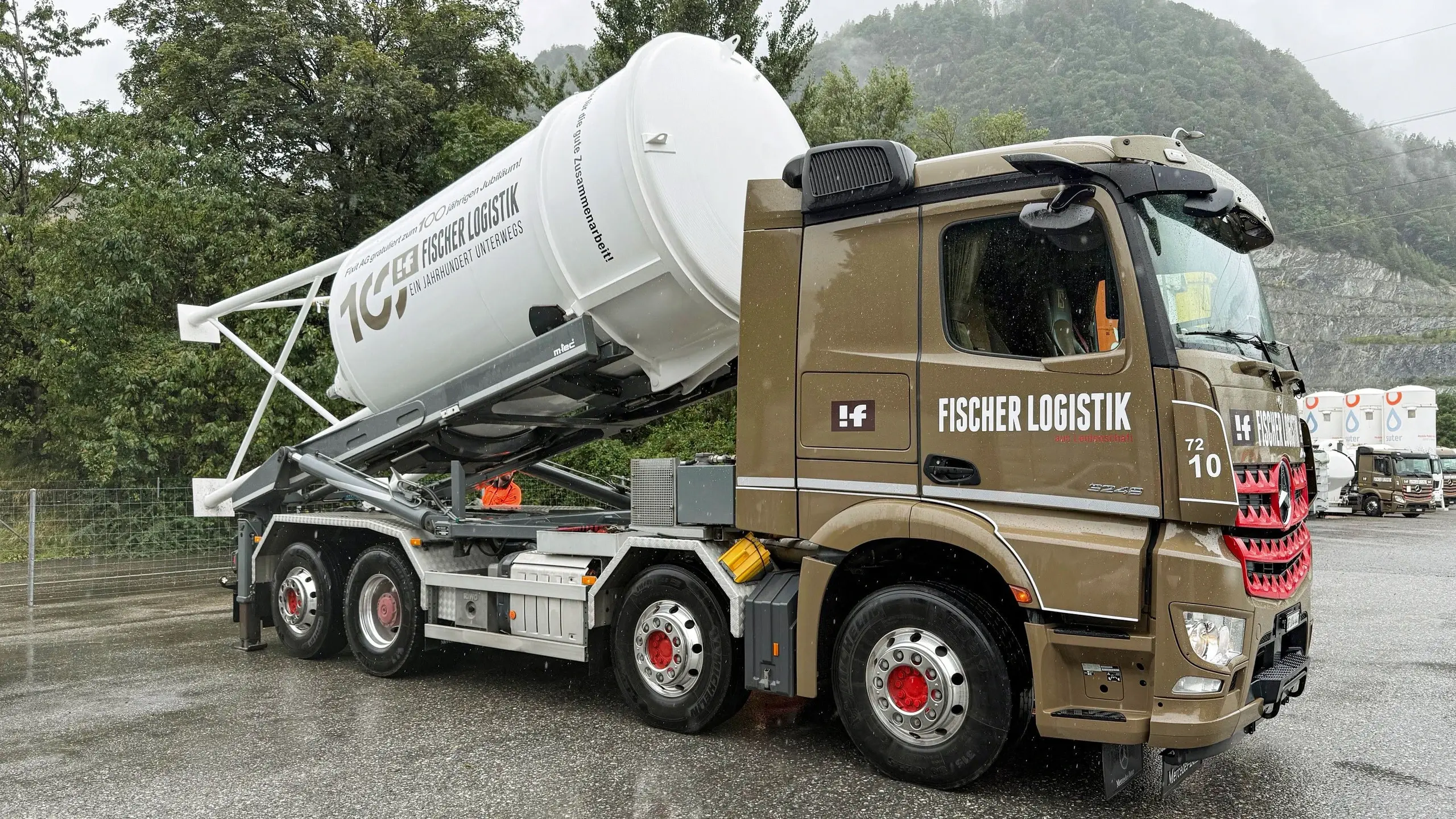 Seitenansicht LKW der Fischer Logistik mit dem weissen Jubiläumssilo der Fixit schräg aufgeladen.
