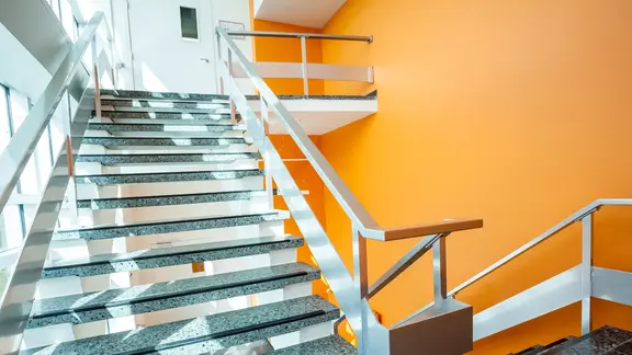 Modernes Treppenhaus mit gelb gestrichenem Wand