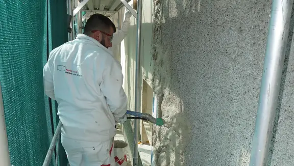 Verarbeiter trägt Fixit 222 Aerogel Hochleistungsdämmputz direkt auf die bestehenden, schadfreie Fassade auf um den Dämmwert zu erhöhen