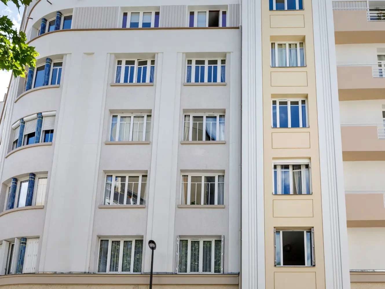 Vista della facciata esterna bianca e giallo crema, adiacente a un altro edificio