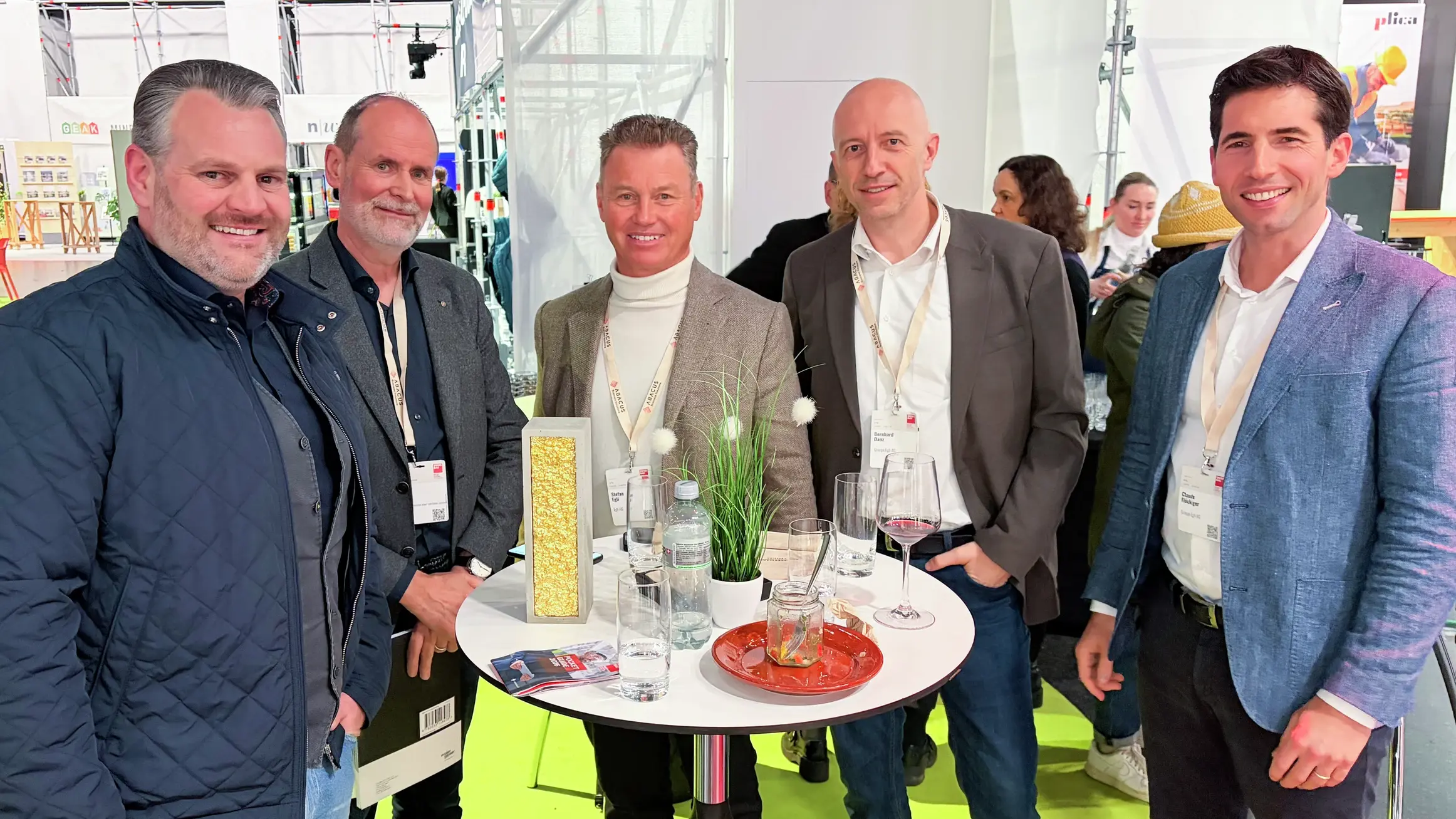 Die Gewinner stehen an einem Stehtisch nach Erhalt der Trophäe zusammen