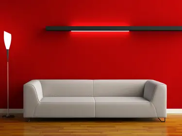 Rote beleuchtete Wand mit Sofa im Vordergrund