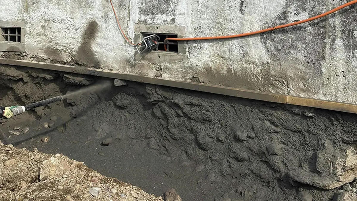 Maçonnerie mise à nu sous le niveau du sol, sur laquelle est projeté le Fixit 526 A, un enduit pour fouilles