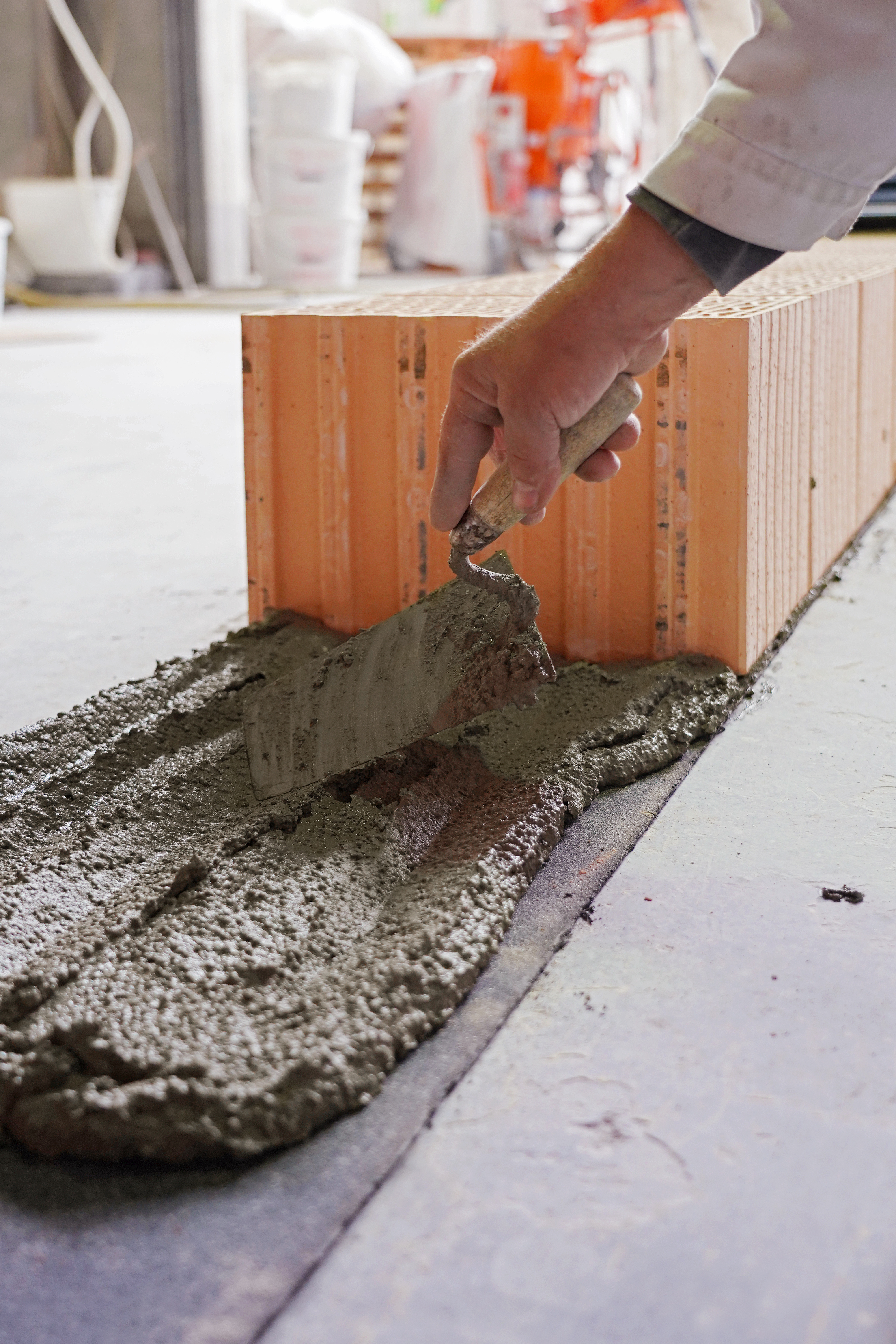 Eine Schicht Mauermörtel wird als erste Schicht auf den Boden aufgetragen.