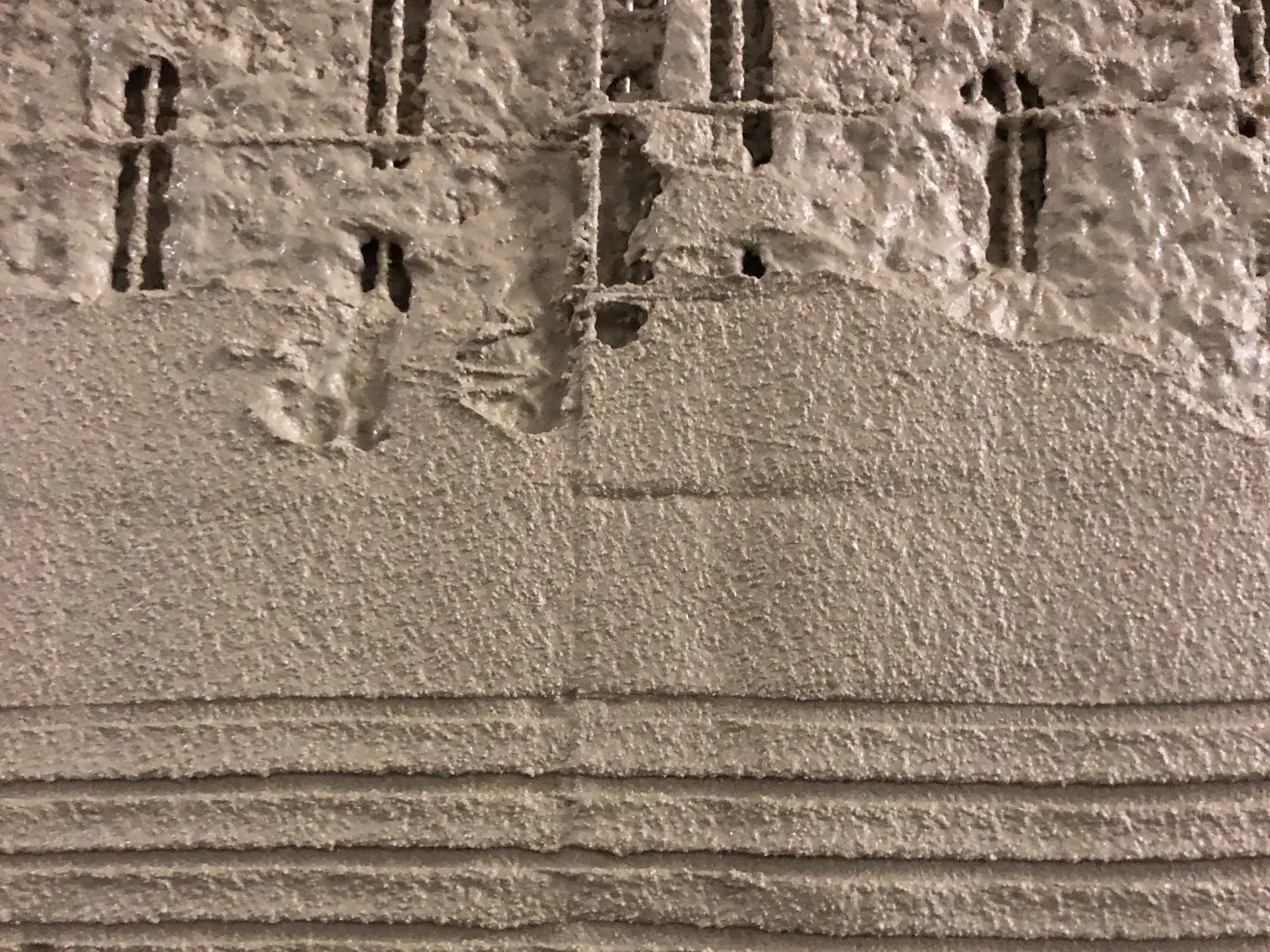 Detailansicht von einem nahezu komplett mit feuchtem Putz überdeckten Stucanet® SH 