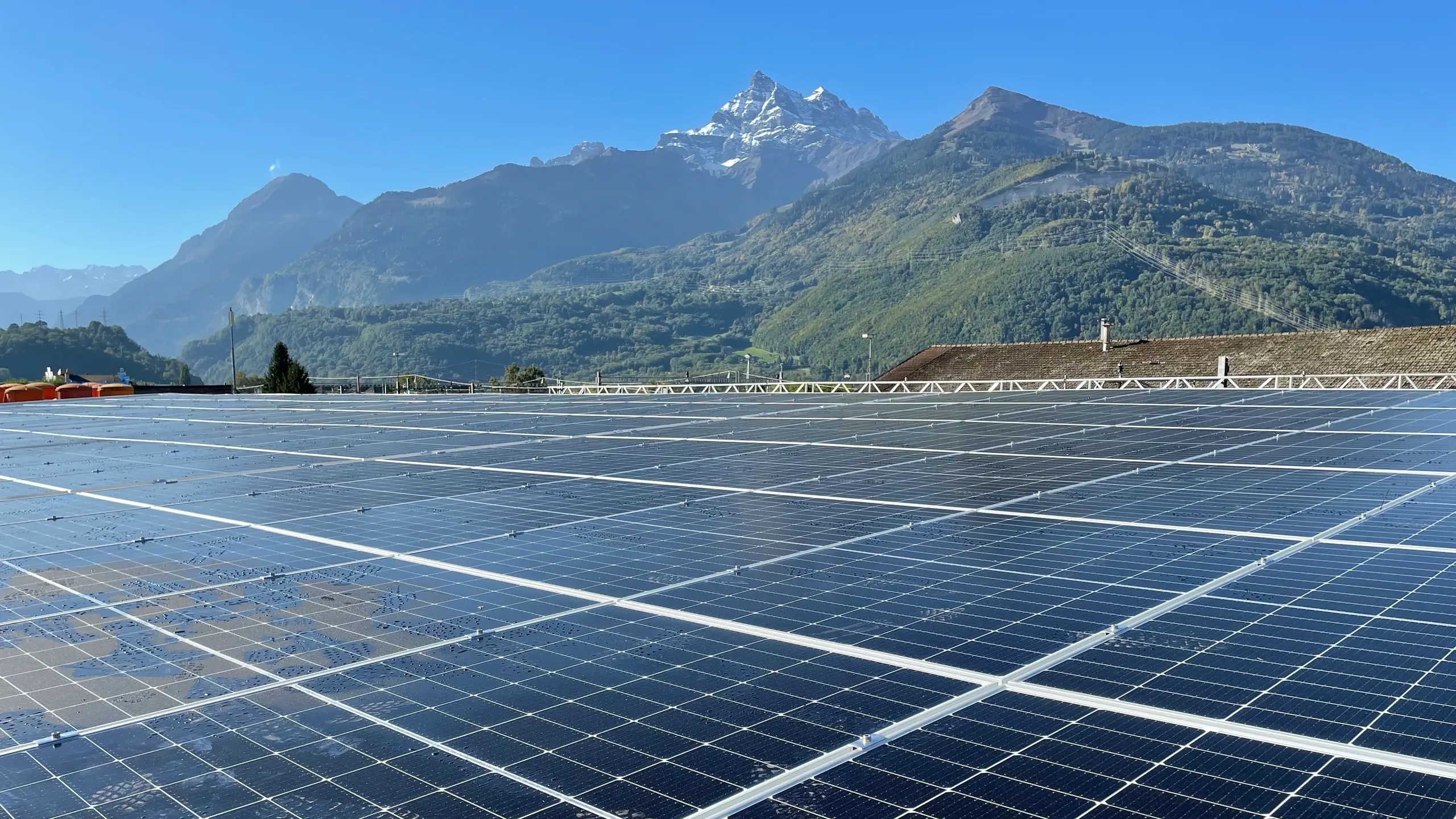 Impianto fotovoltaico su tetto piano con panorama montano sullo sfondo
