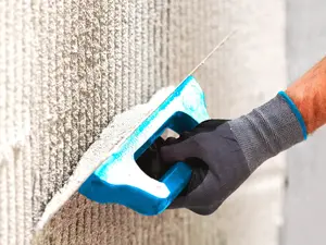 Nahaufnahme eines Verputzers bei der Arbeit 