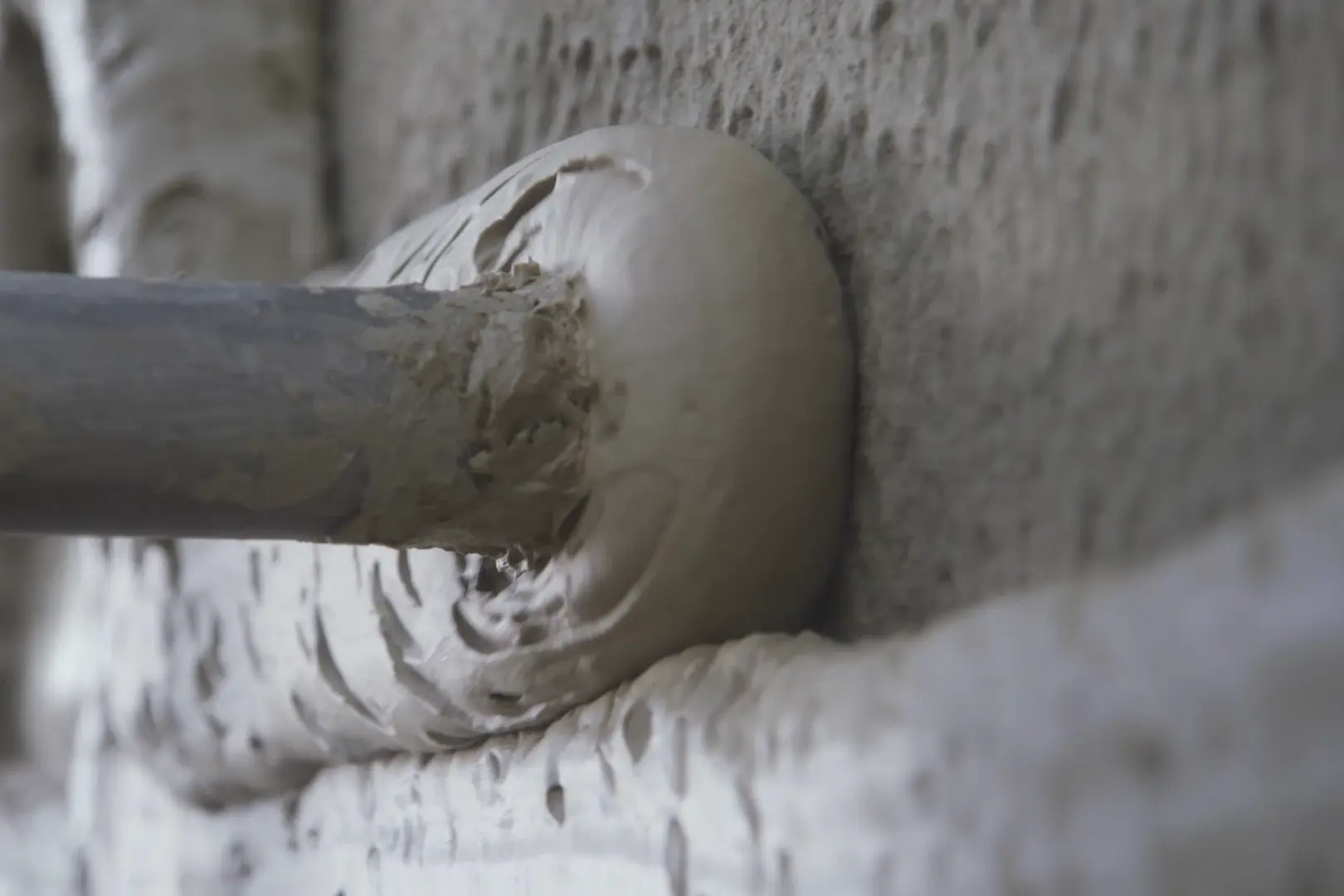 Maschinelles Aufspritzen von FOME® Dämmputz auf eine Gebäudeaußenwand