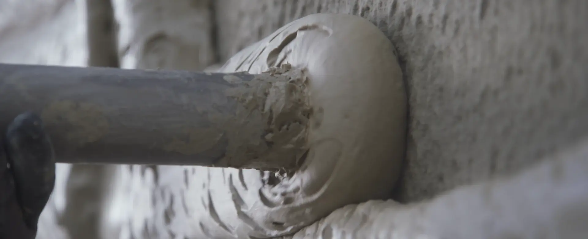 Maschinelles Aufspritzen von Dämmputz als effiziente Methode der Fassadendämmung auf einer Gebäudeaußenwand