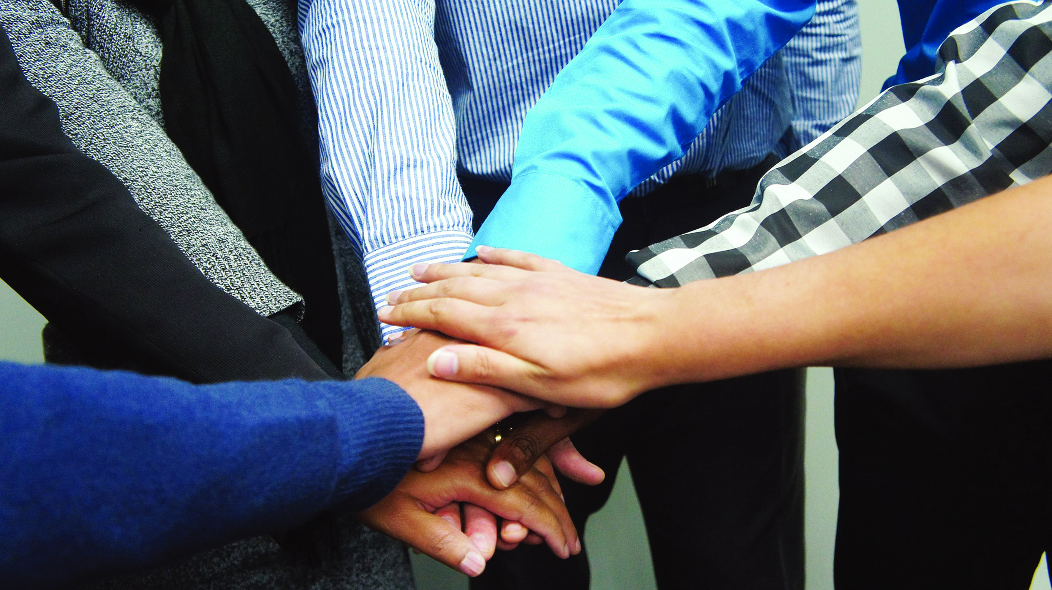 Hände sind zusammengelegt als Zeichen von Teamarbeit.